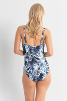 Woman wearing a blue and white patterned swimsuit on a plain background