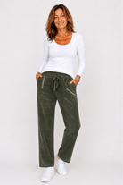 Woman wearing a white top and green pants on a white background