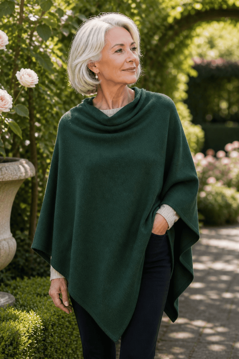 Woman wearing a green poncho in a garden setting